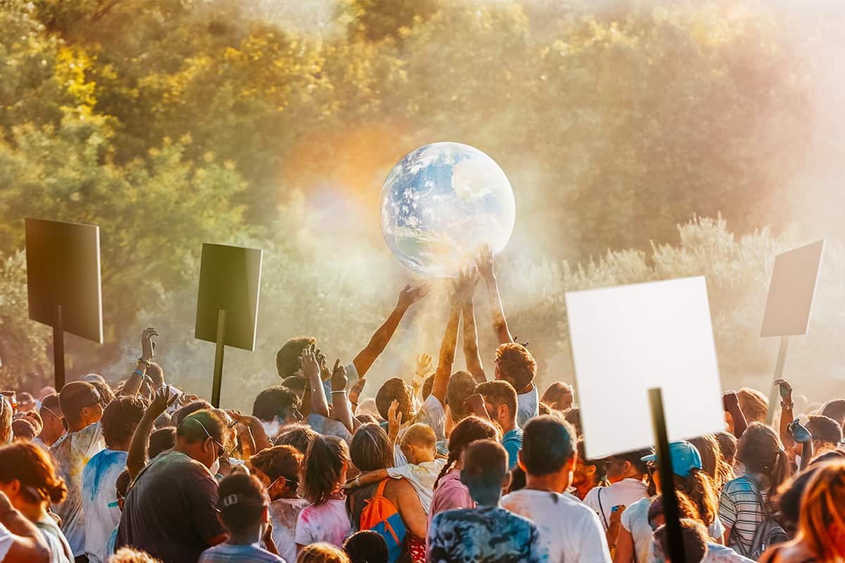Streikende Masse die den Planeten halten © AdobeStock/ OSORIOartist Menschen beim Streiken halten den Planeten