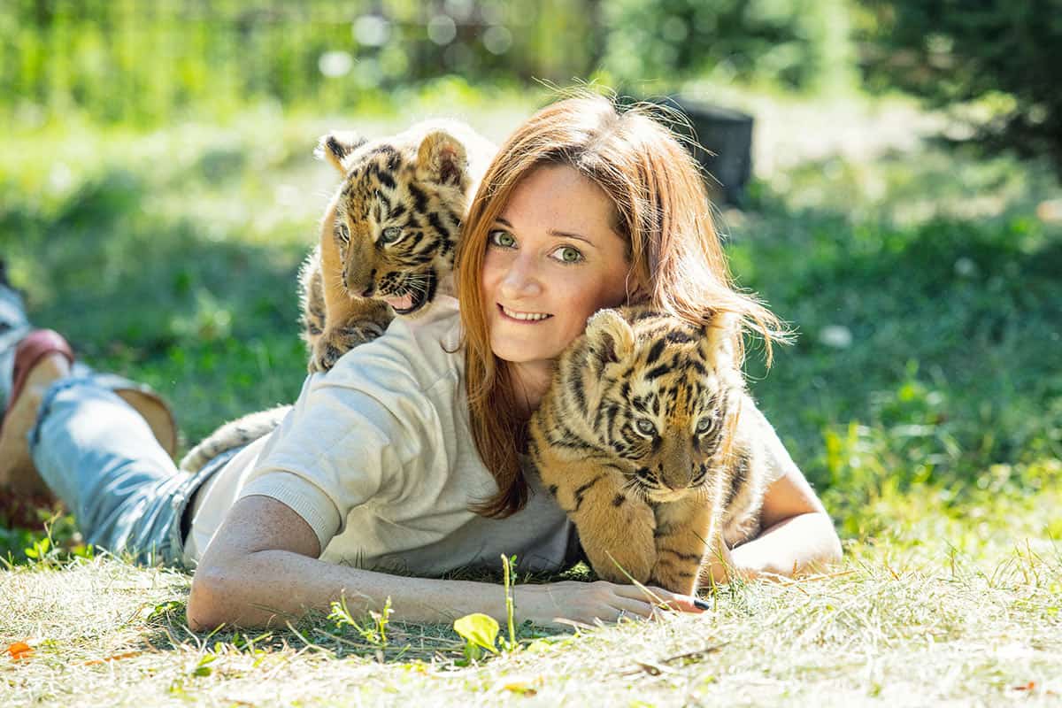 Frau kuschelt mit Tigerbabys(c)AdobeStock Frau kuschelt mit Tigerbabys