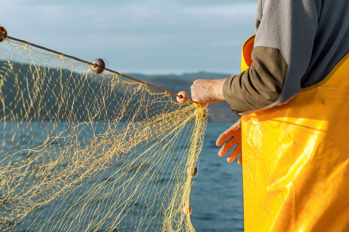 Fischer mit Fischernetz auf Boot Fischer mit Fischernetz auf Boot
